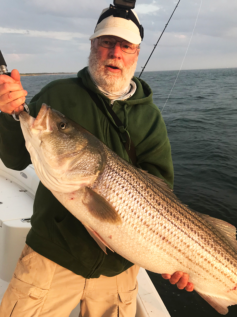 angler-john-skinner-on-charter-boat-with-striped-bass.jpg