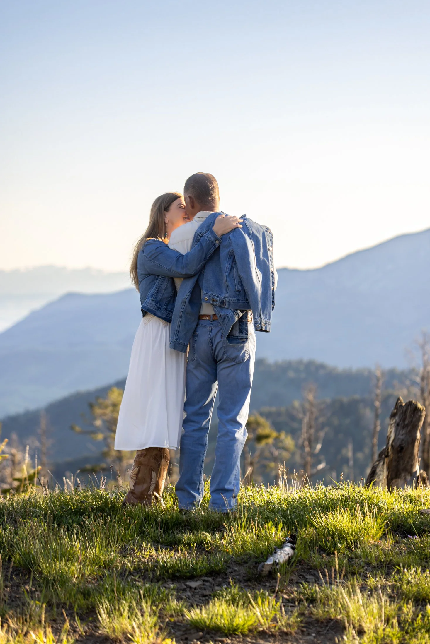 A bride-to-be showers her husband to be with affection as they stand on the edge of an overlook during their Montana engagement session.