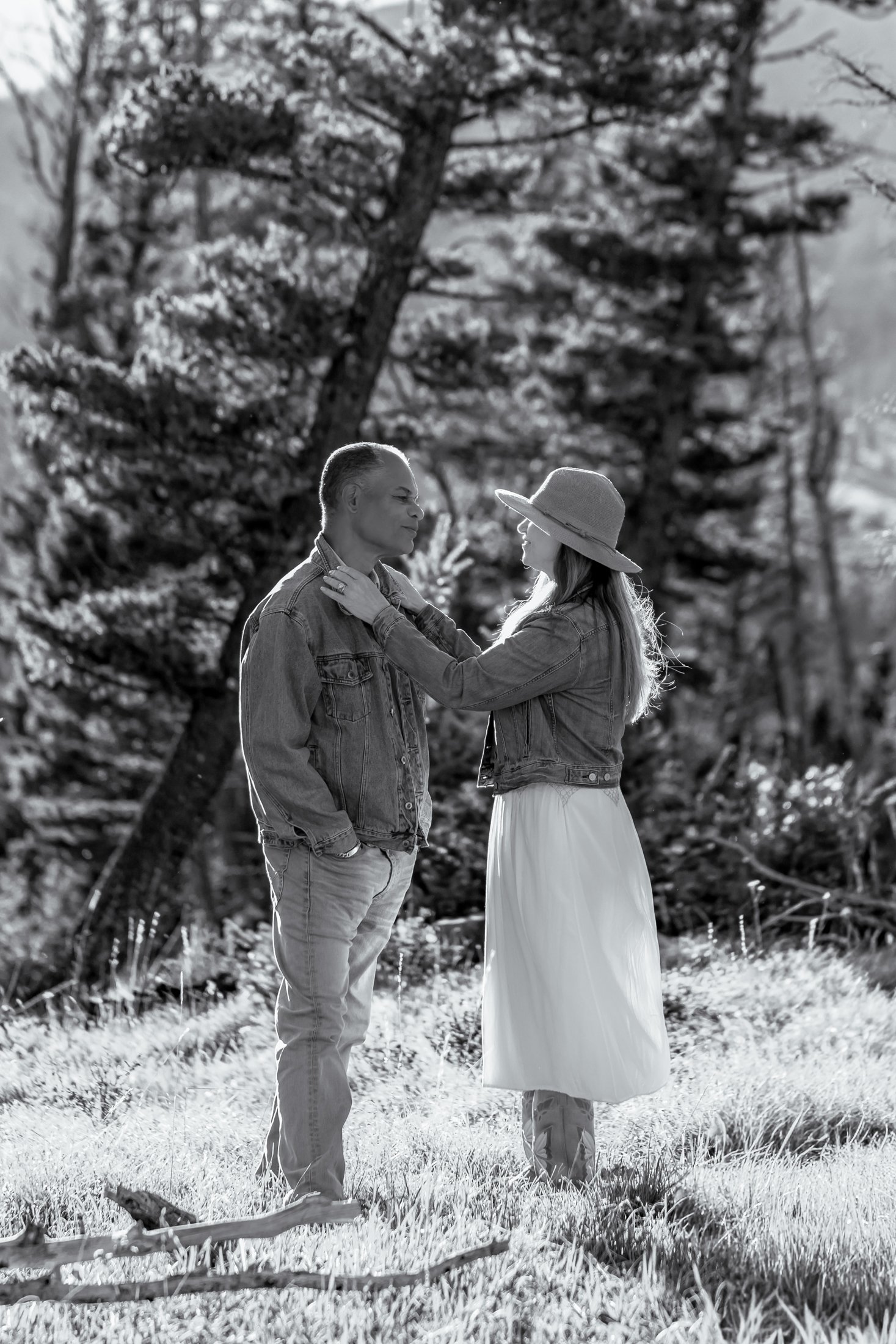 A Black and white image of a couple facing each as she lovingly fixes his collar so they can continue with their Montana Engagement Session.