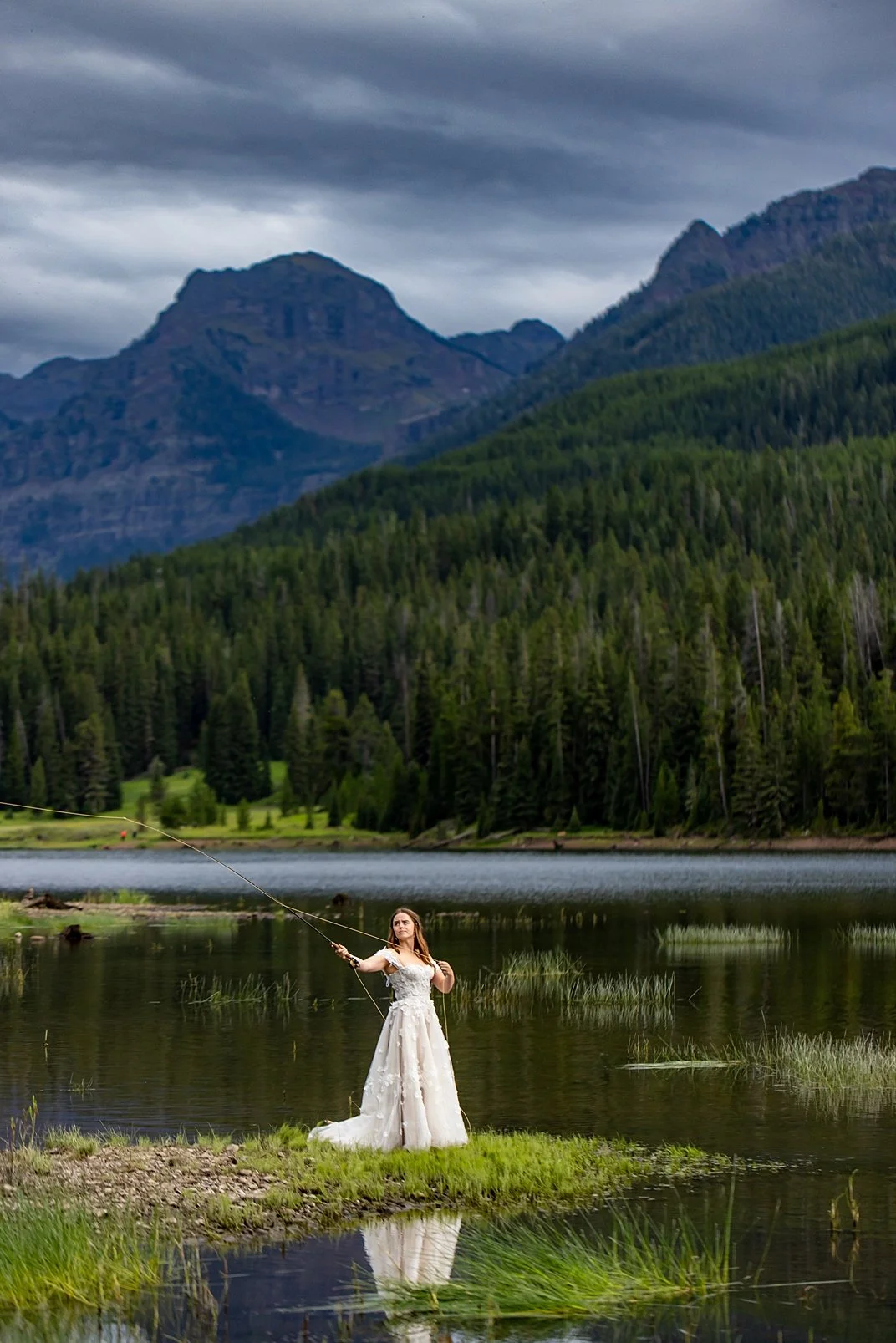 A bride flyfishing in her wedding dress in the mountains of Montana