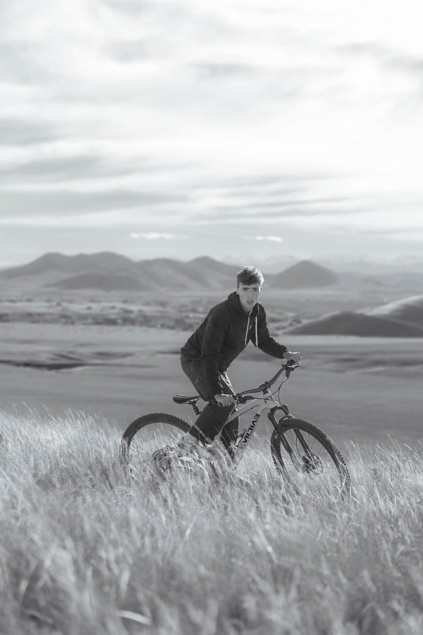 Black and white image of a Bozeman Senior riding his mountain bike in the hills around Three Forks Montana.