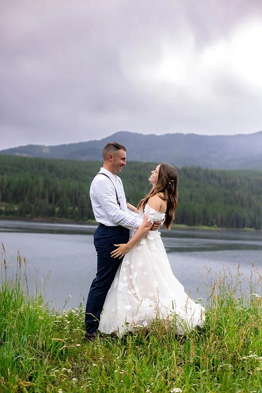 Bride and Groom standing on a lookout over Montana's Hyalite Reservoir.