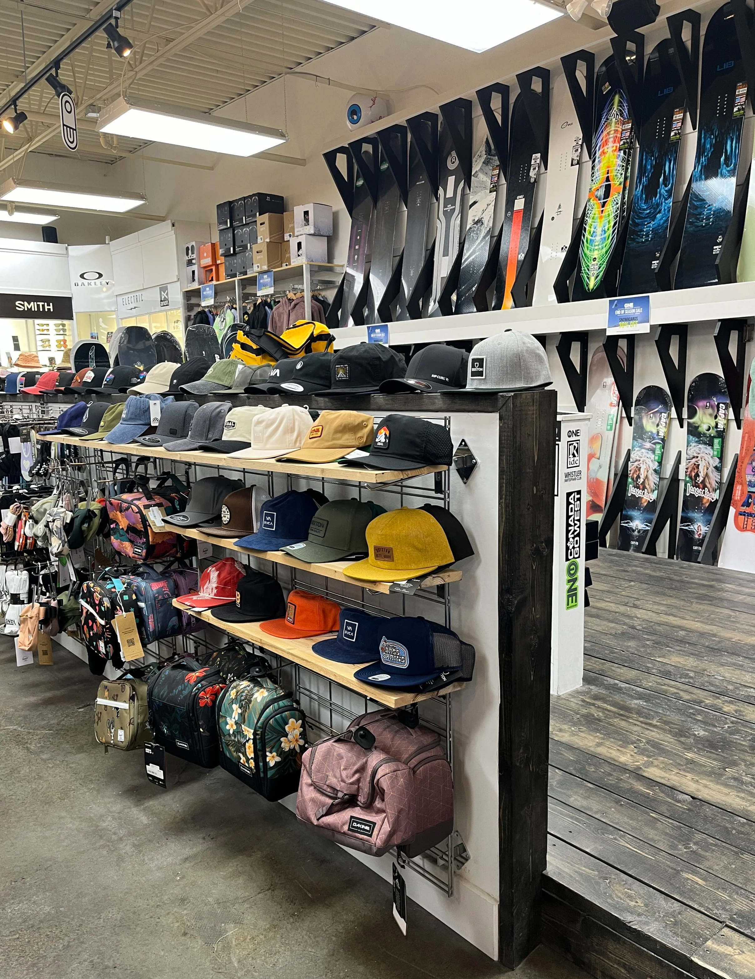 Display of various hats and caps on shelves with skateboards mounted on the wall in the background.