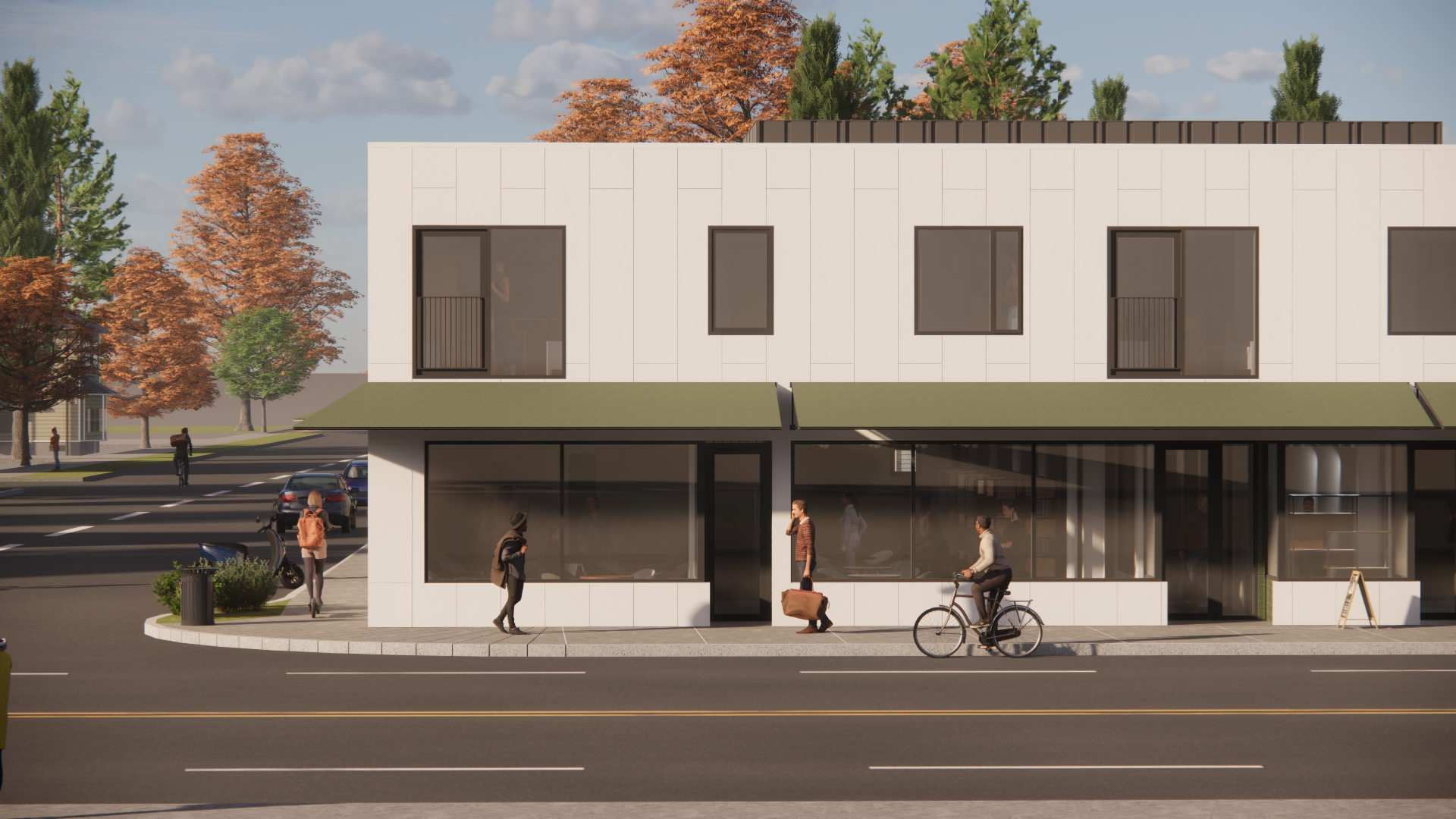 Modern building with retail storefronts on a city street, people walking, biking, and cars parked nearby, autumn trees in background.