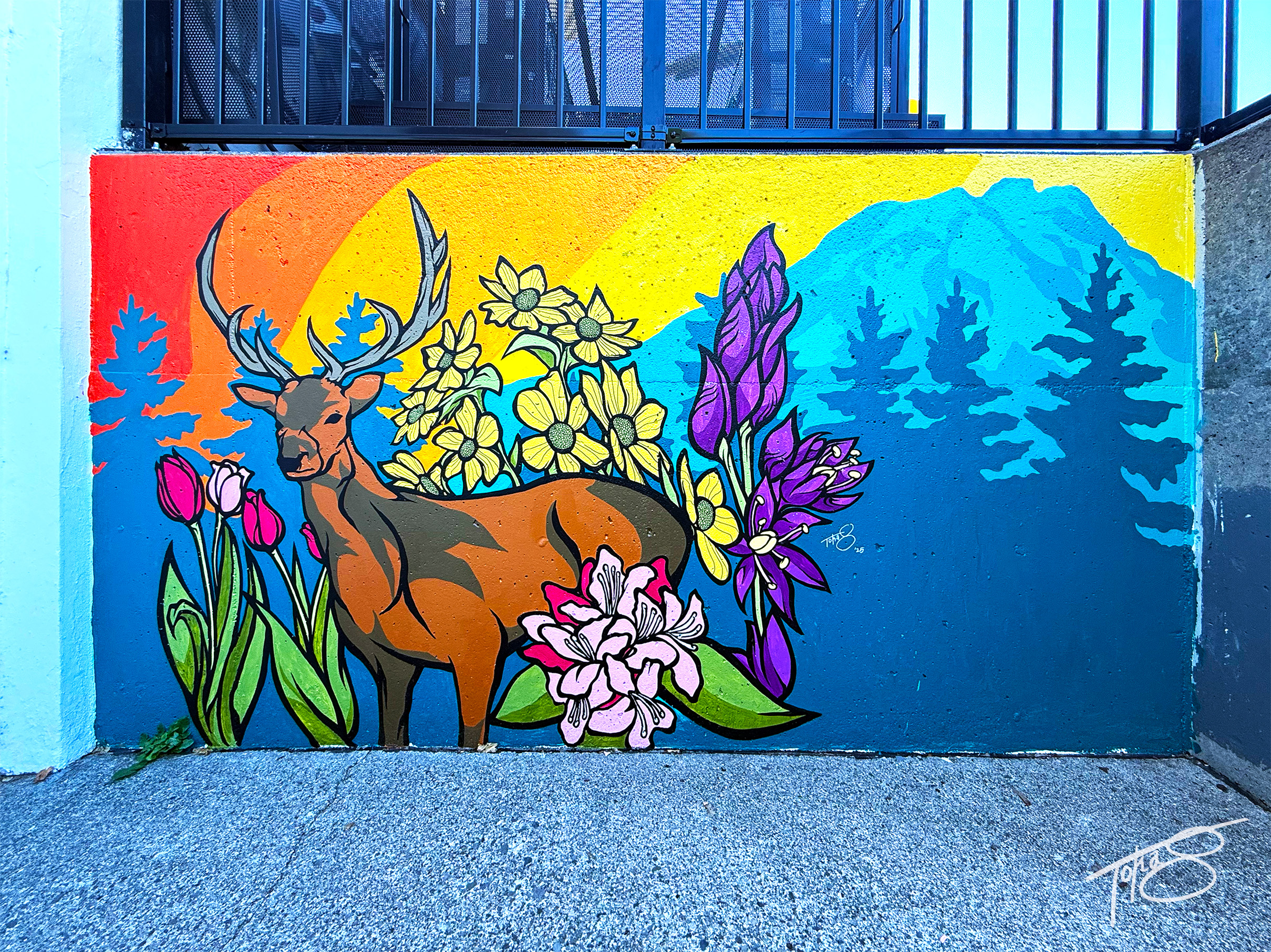 Postmark Mural of brown deer with colorful flowers and vibrant mountainous background