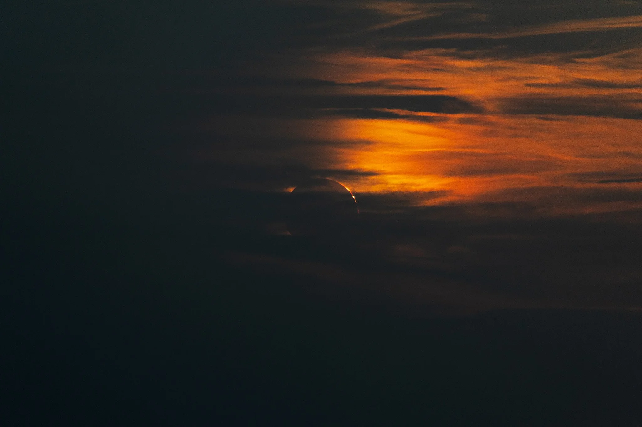 The end of totality during the 2026 total solar eclipse with some orange color clouds on the top right as photographed from Menorca, Spain.