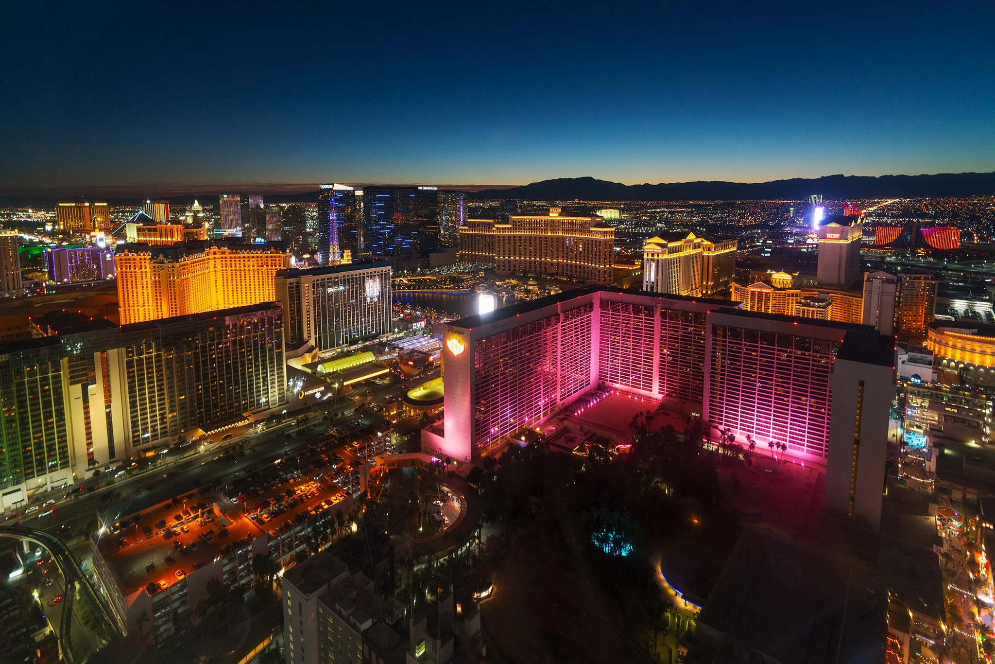 A nighttime view of the Las Vegas strip from the High Roller Ferris wheel featuring the Flamingo Hotel in the midground and The Cosmopolitan in the distant.
