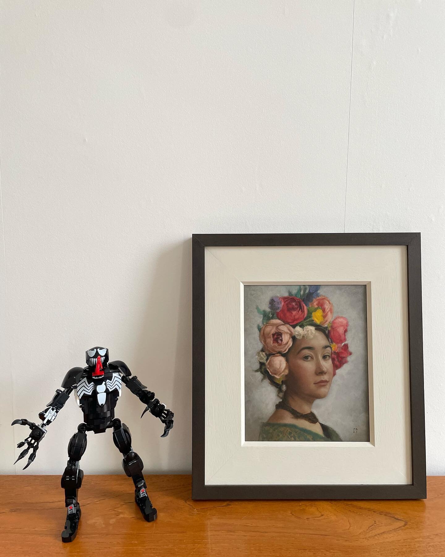 Venom kindly guarding Girl in a Flower Headdress by @zarakuchiart during re-hang! #painting #portaiture #curation #gallerywall