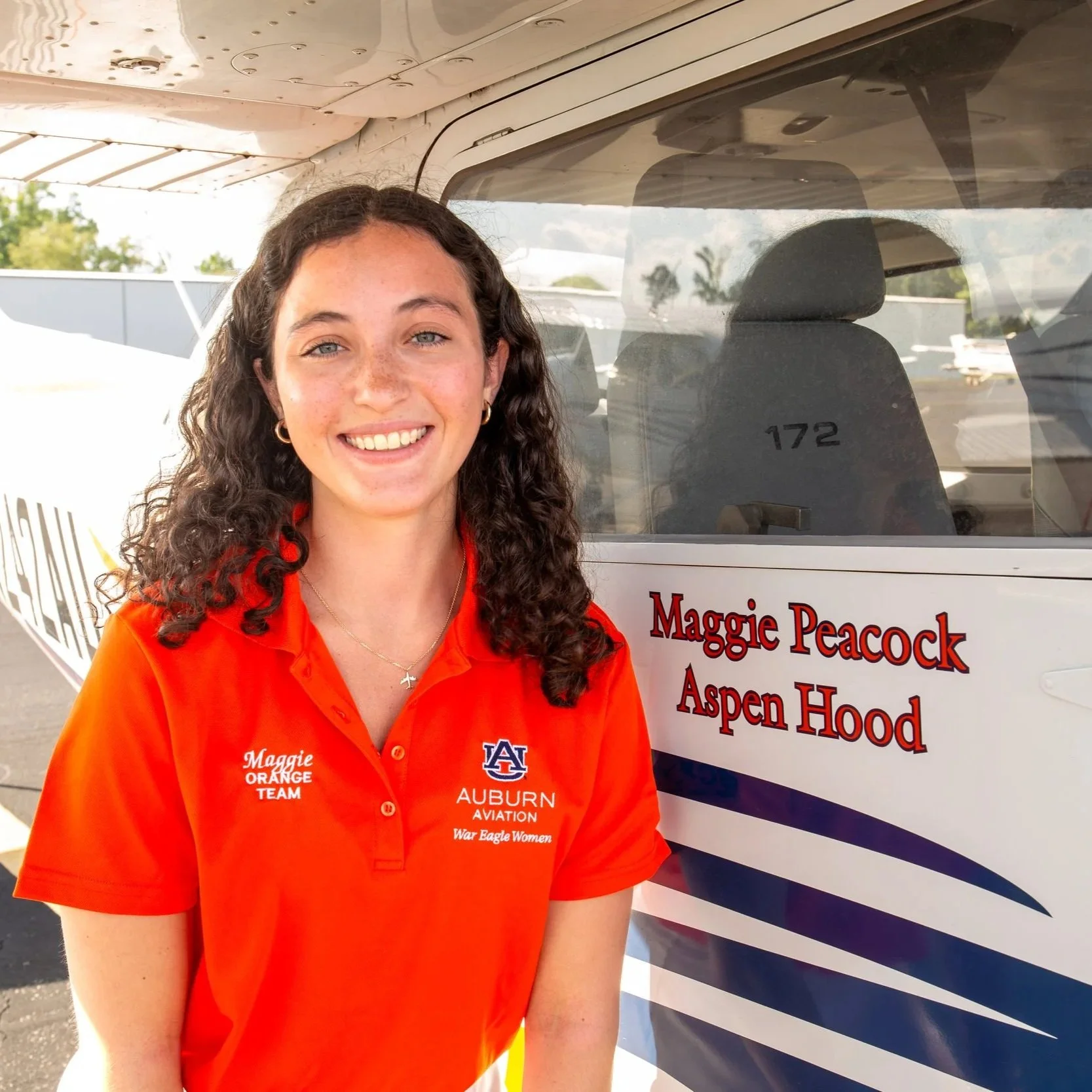 Maggie Peacock standing next to her name on plane 64