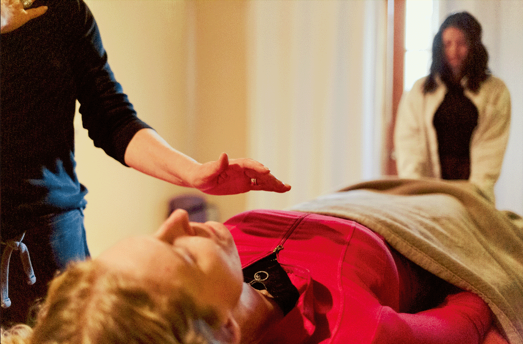 Two practitioners performing reiki on patient