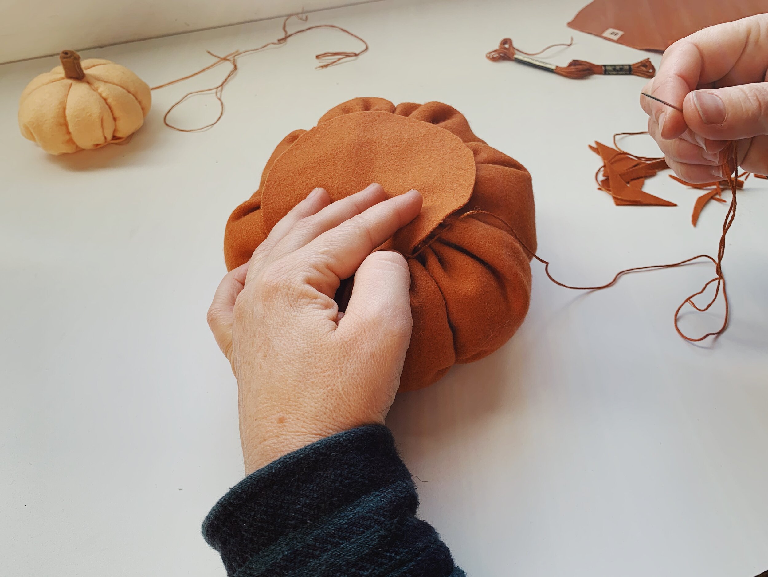 Stitch the circle to the base of the pumpkin