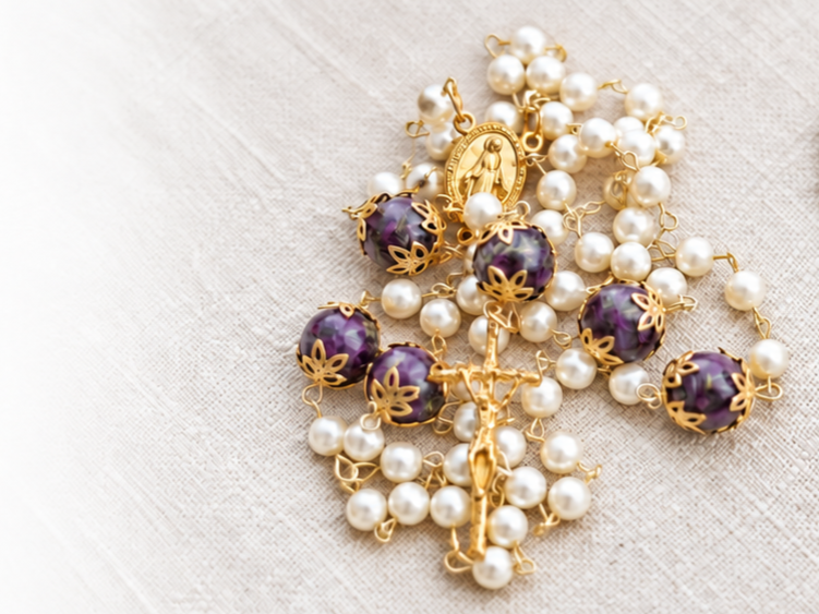 Gold memorial rosary with white pearls and purple accent beads.
