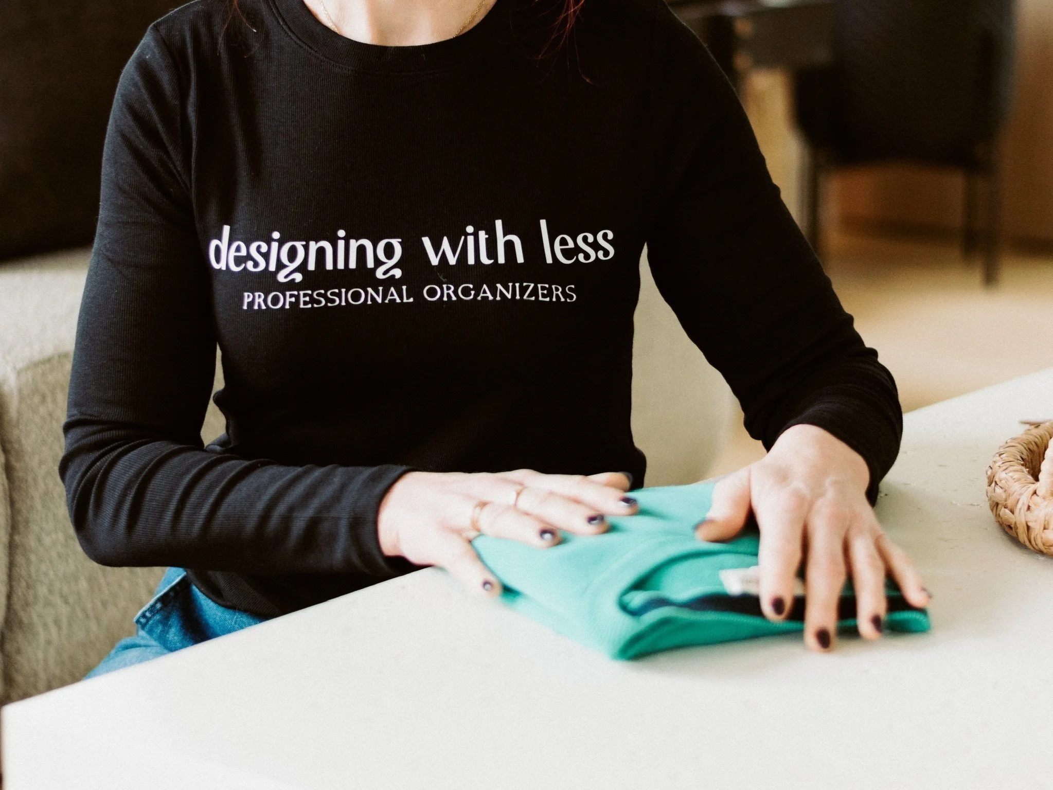 Michelle from Designing with Less, Atlanta, carefully folding a green sweater