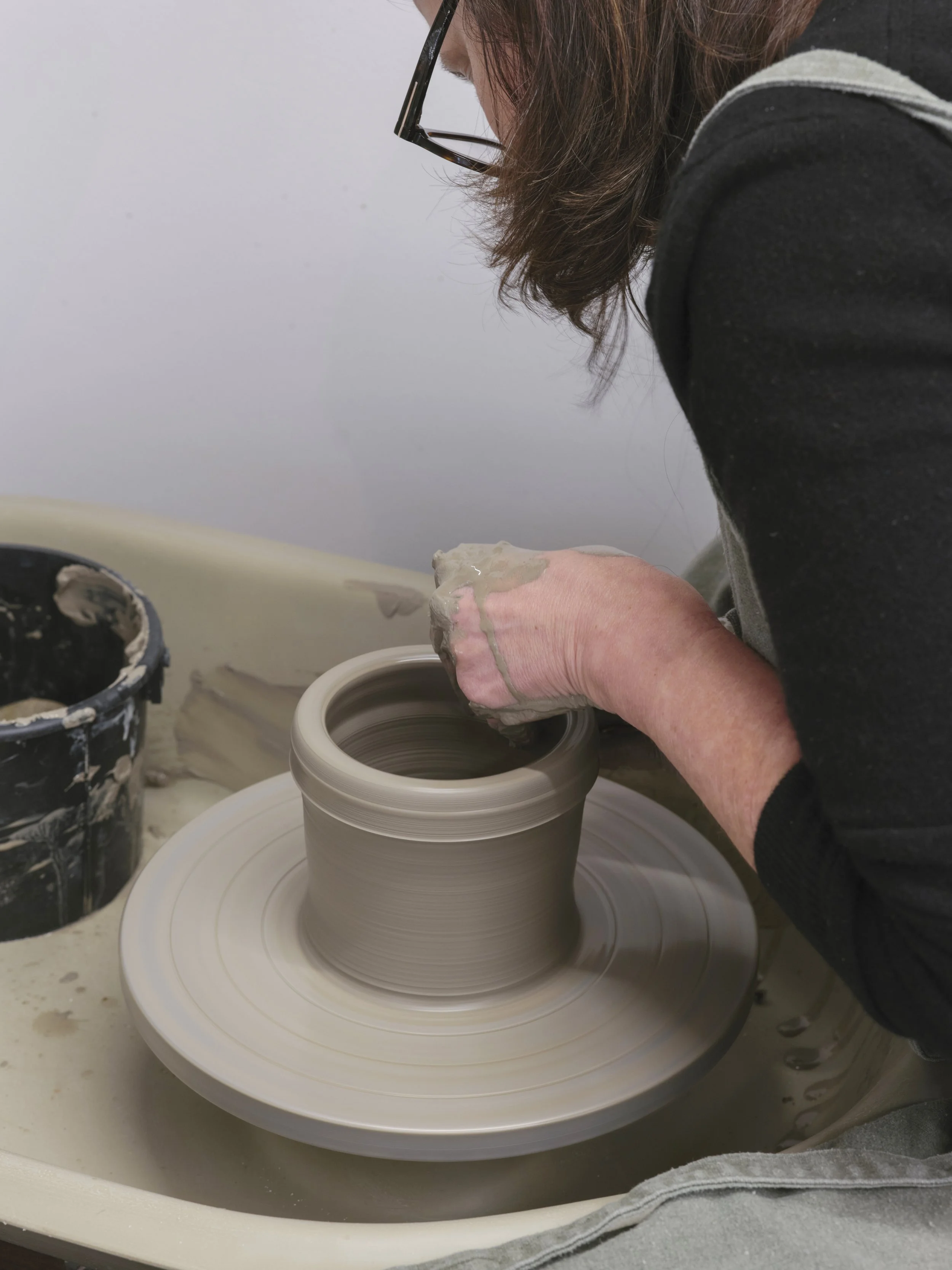 Marija Bichan shaping a ceramic piece on a pottery wheel in a studio.
