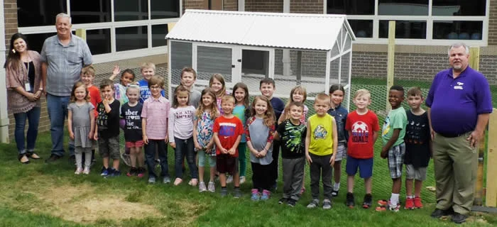 The kindergarten class responsible for the chicken coop behind Boonesborough Elementary School stands in front of the new structure along with, far left: teacher Tori Golden and head custodian Elmer Perkins, who helped build the coop, and, far right, Madison County Schools Food Services Director Scott Anderson. (Kentucky Department of Agriculture photo)
