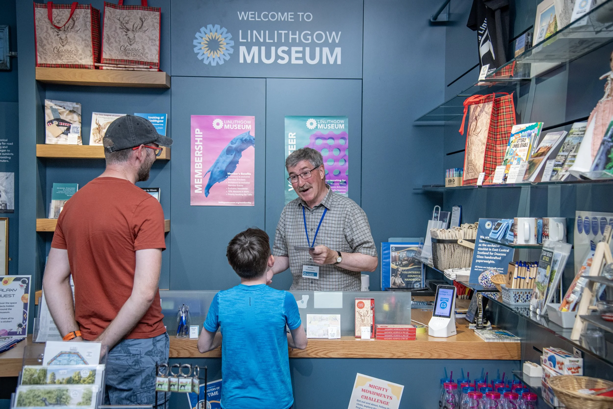 This shows one of our volunteers welcoming a father and his son to the museum