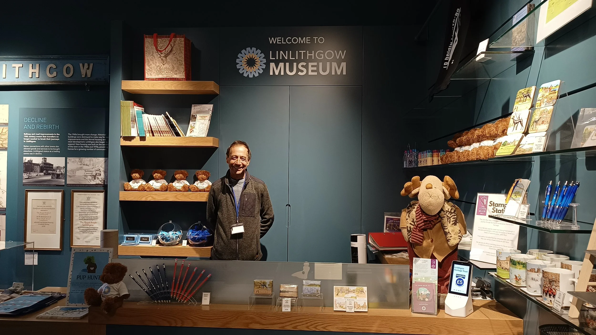 Entrance to museum gallery and museum shop with volunteer standing behind the desk