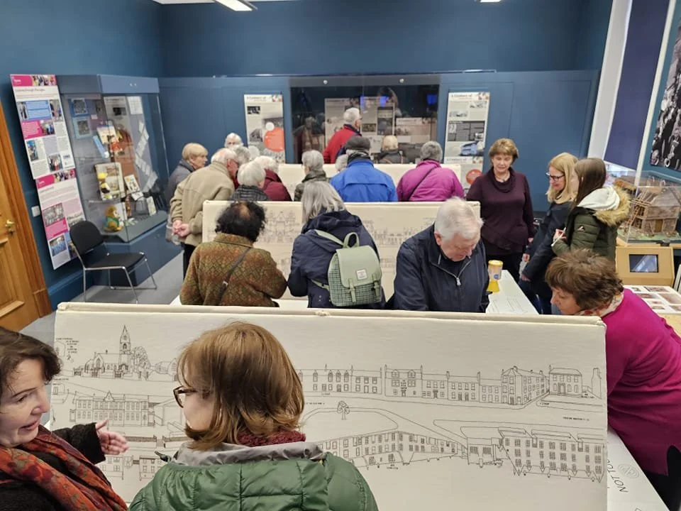Visitors exploring a community exhibition featuring the Linlithgow Embroideries at Linlithgow Museum.