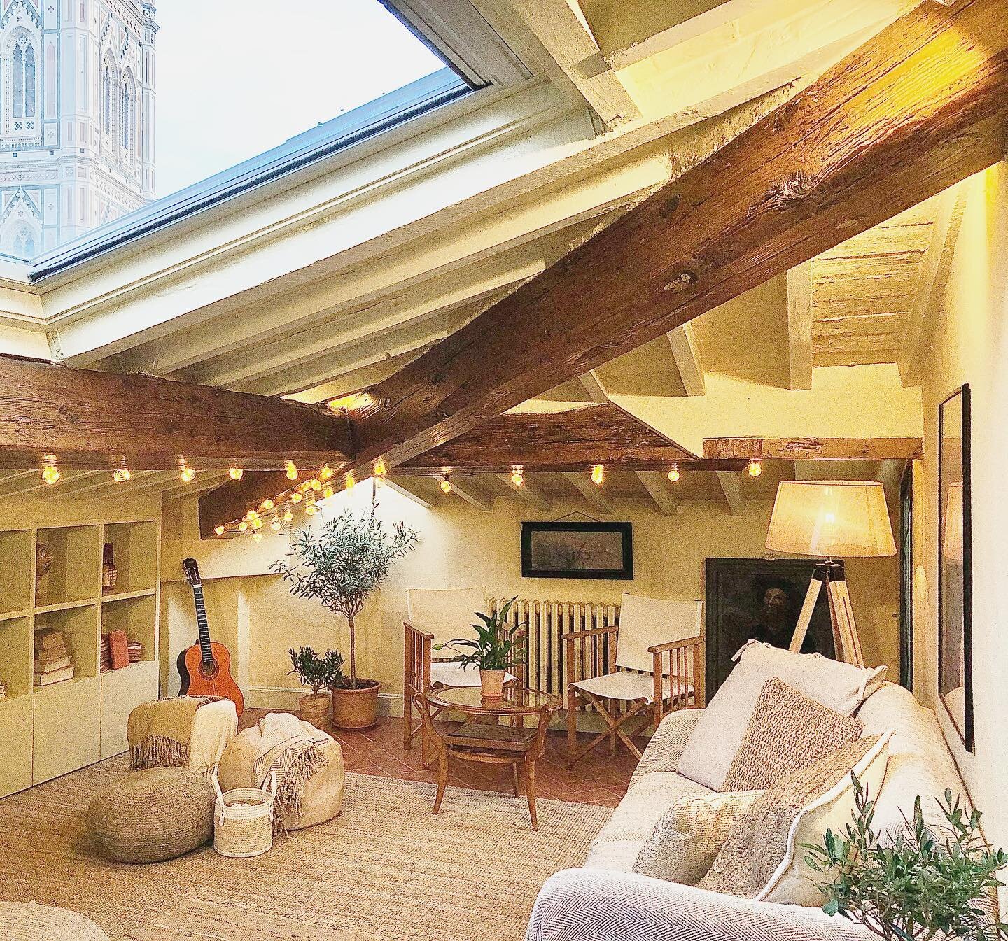 The snuggle corner! Living room with sloped ceilings, 400-year-old wooden beams, and skylight windows with Duomo view.