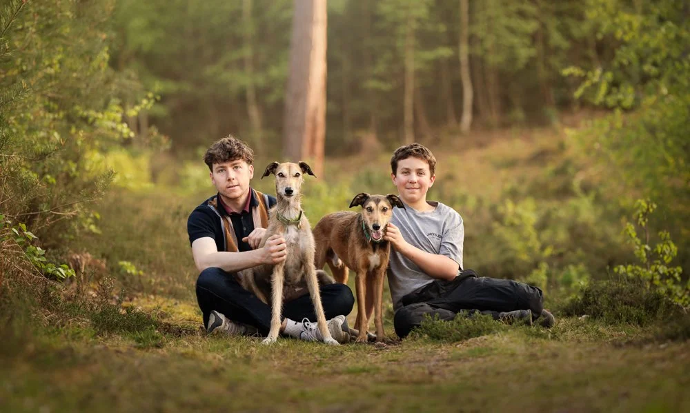 Photo of two teenagers and their two lurchers during a family photoshoot in Midhurst, West Sussex