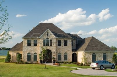 443486-very-large-and-beautiful-stone-and-brick-house-on-a-small-lake-with-generic-car-in-front-circle-driv.jpg