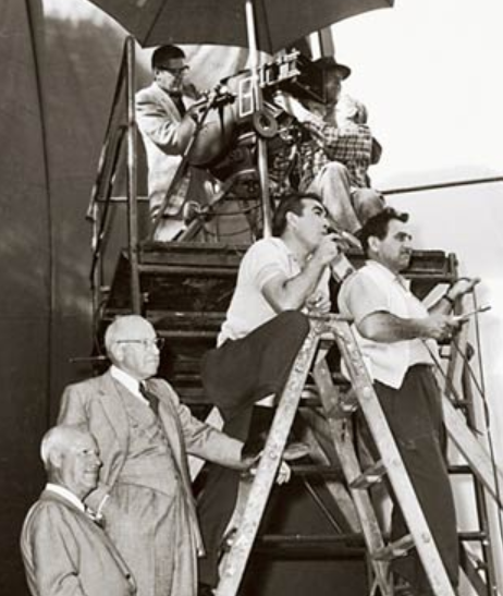 Anthony directing The Buccaneer from atop ladder, with Cecil B. DeMille watching from directly below, left, 1958
