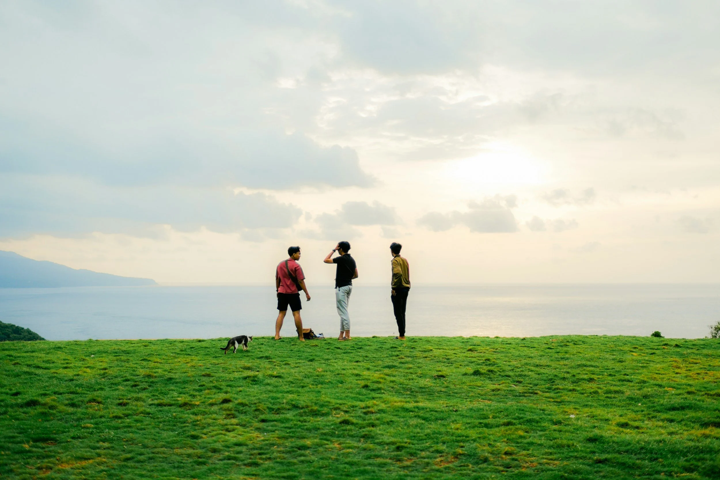 Image of three people outdoors talking.