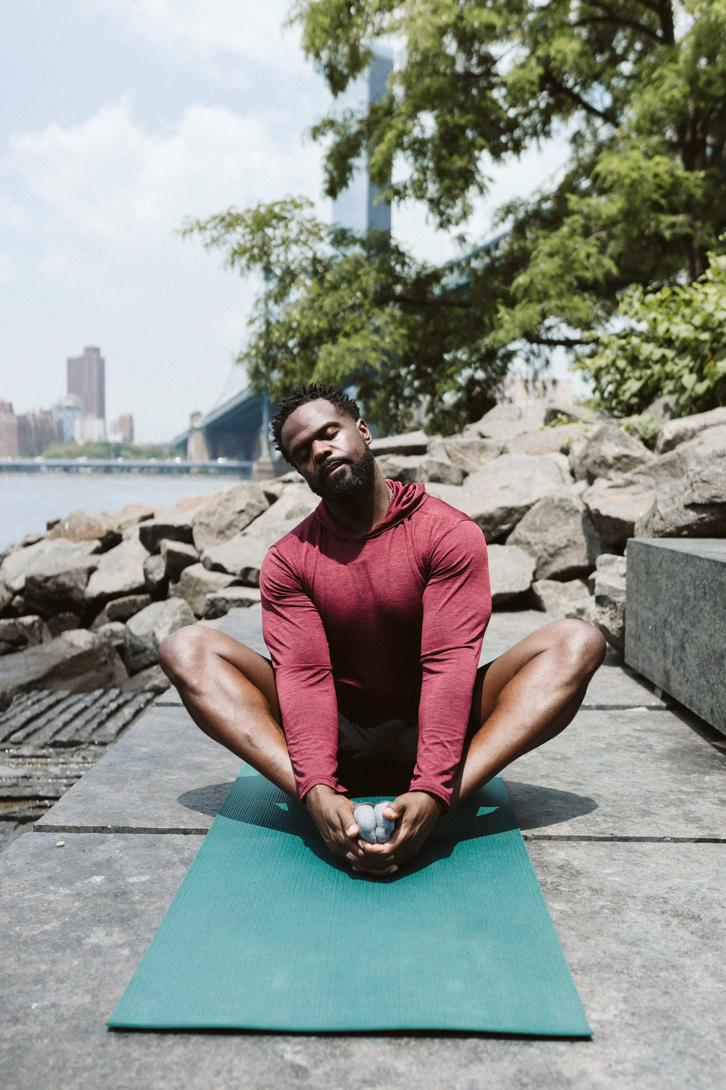 Courtney Brame founder of something positive for positive people doing yoga under the Brooklyn bridge