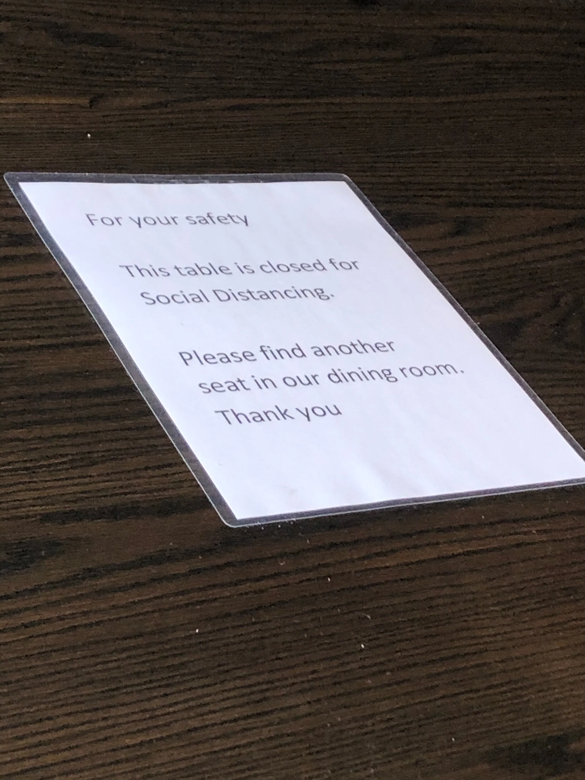 A sign on a table at a local restaurant