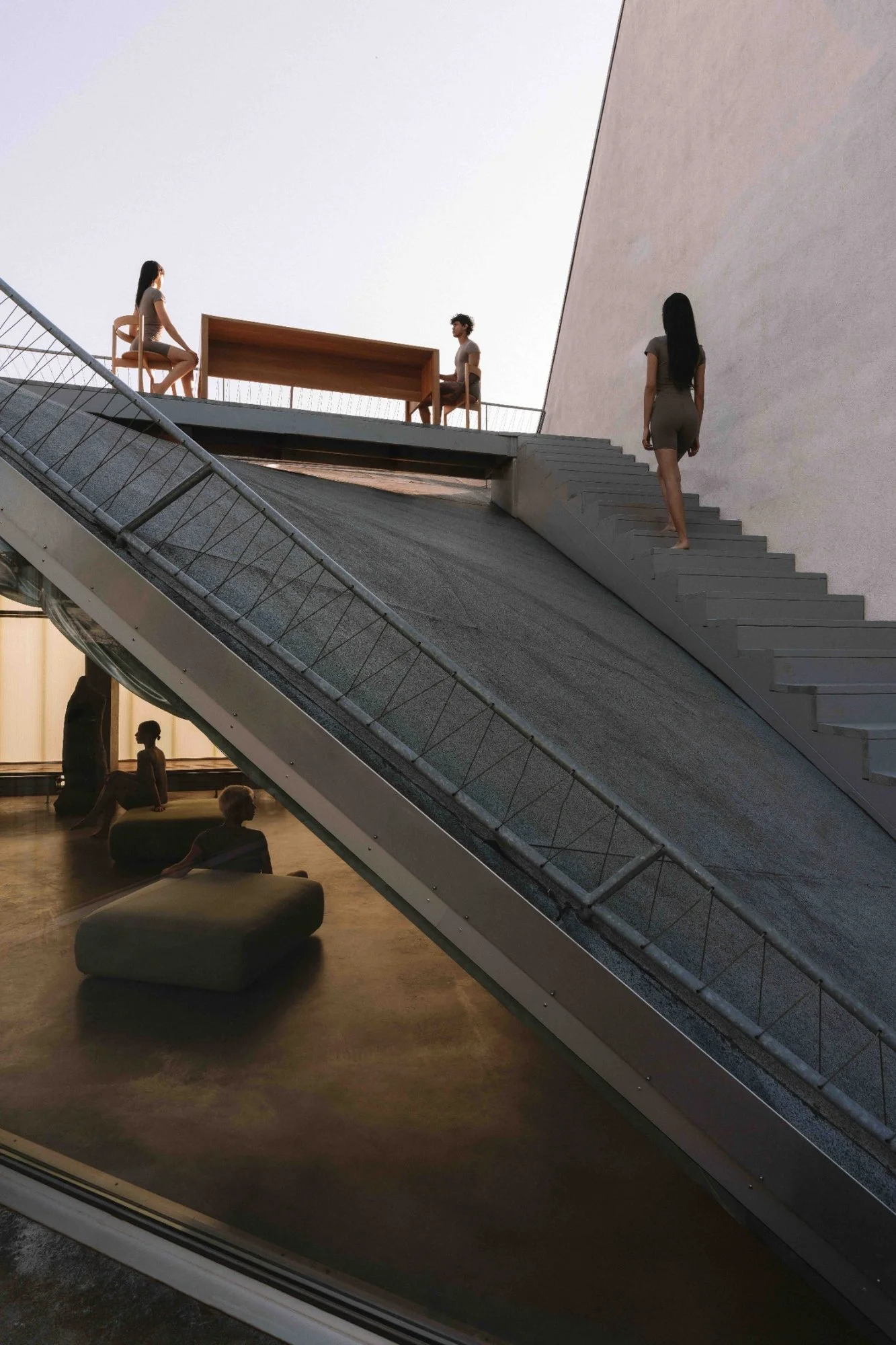 Rooftop terrace at ANTI Berlin with people gathering around a wooden table and relaxing beneath an exposed concrete staircase.