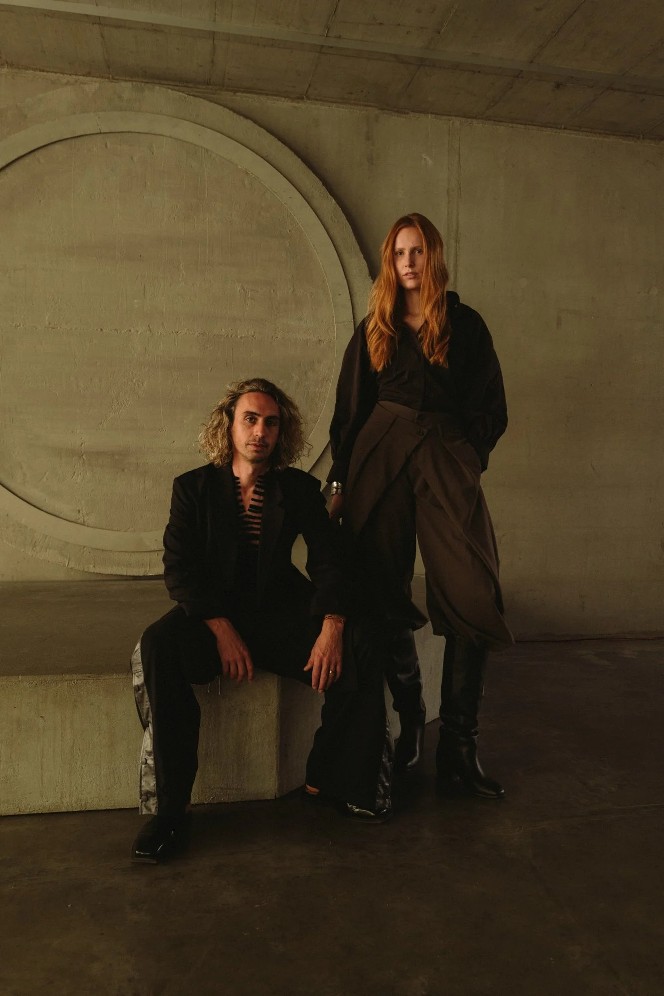 Portrait of ANTI co-founders Yoel Sartras and Antonia Benecke inside their Berlin wellness space, surrounded by raw concrete architecture.