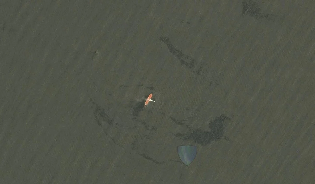 The fire on the Front Altair was spotted being extinguished by another boat. Pollution can be seen in the surrounding area.