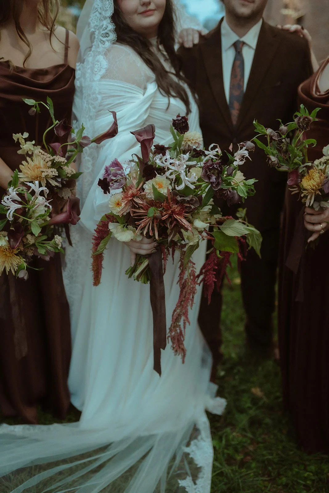 A bride holding a colorful bouquet standing between bridesmaids and a groom at a wedding ceremony.