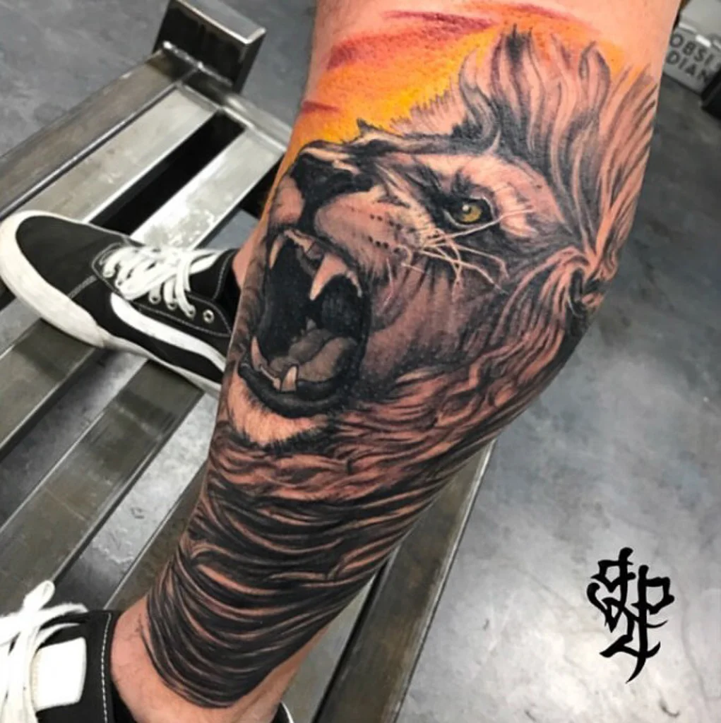 Custom Black and Grey Roaring Lion and Orange Sunset Tattoo by Greg Paquin at Certified Tattoo Studios Denver CO .jpg
