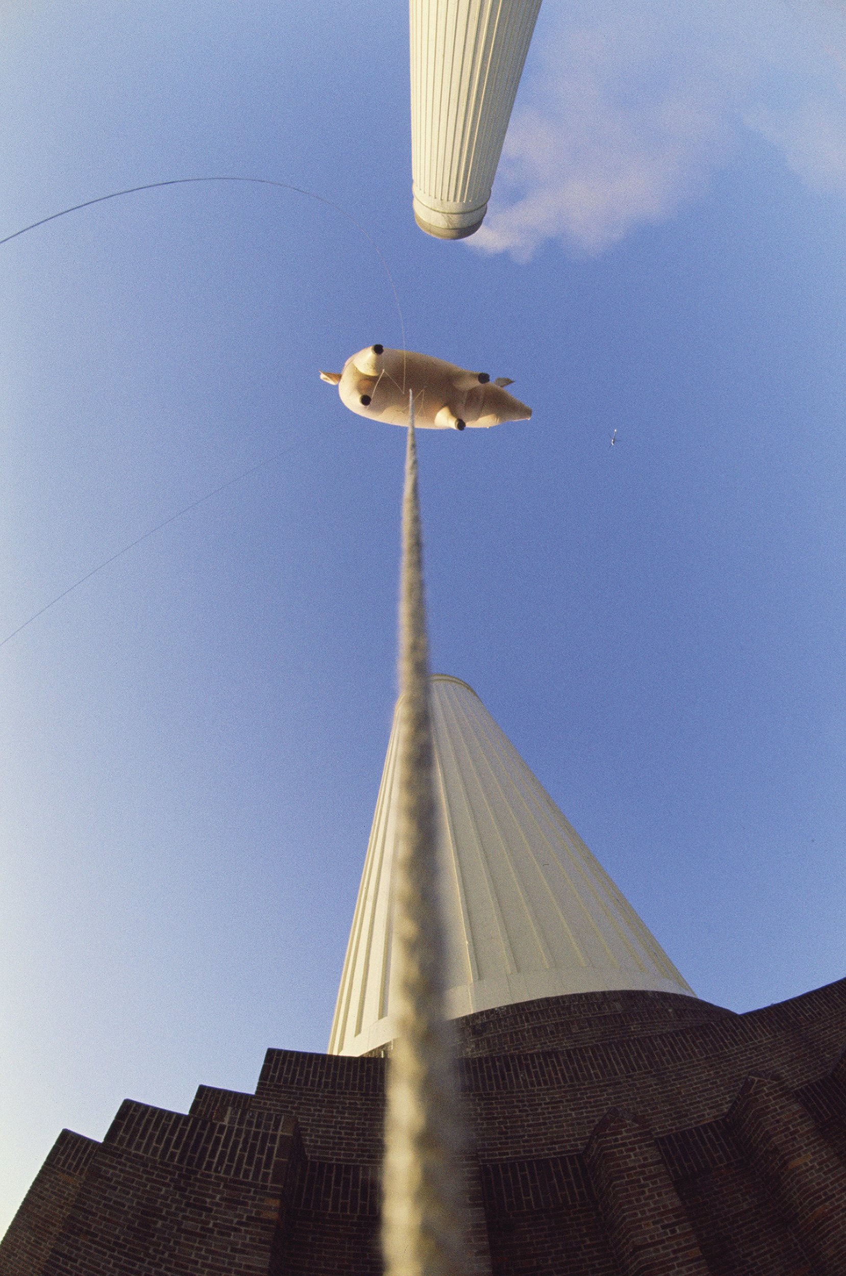 photograph taken from below of the tethered pig floating between the two large chimneys at battersea power station 1976 (c) pink floyd music ltd.jpeg