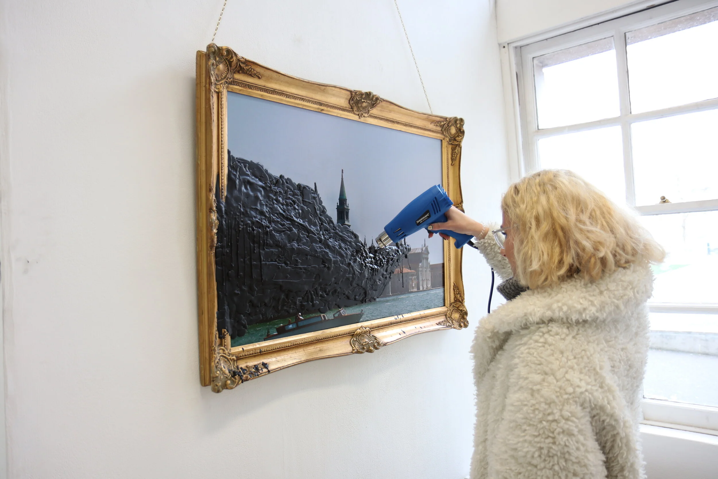 Viewers are invited, sometimes by an attendant or through instinct, to take a heat gun located nearby and start to melt the waxy layers.