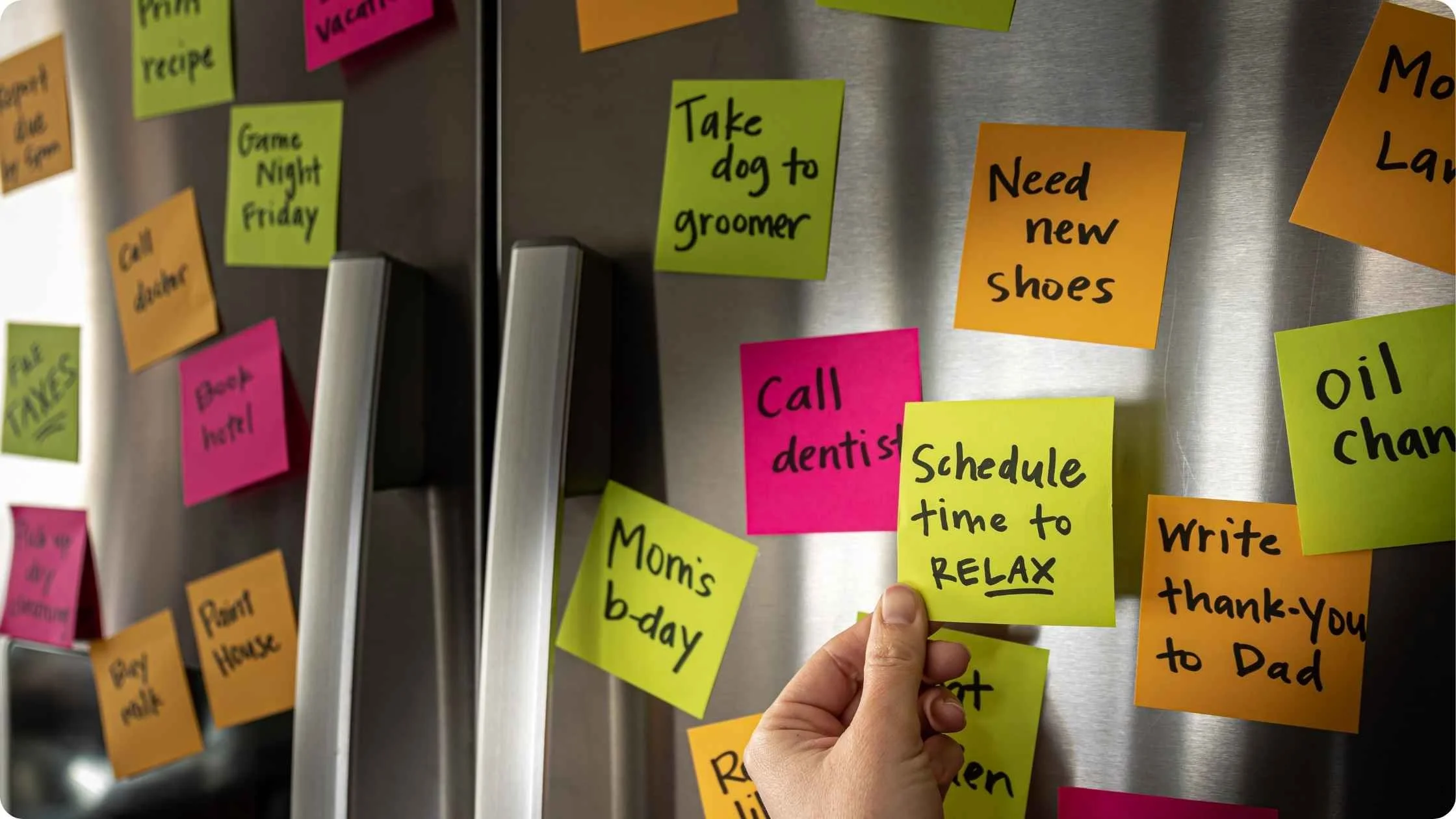 Fridge covered in colour-coded to-do notes, including one reading 'Schedule time to relax.