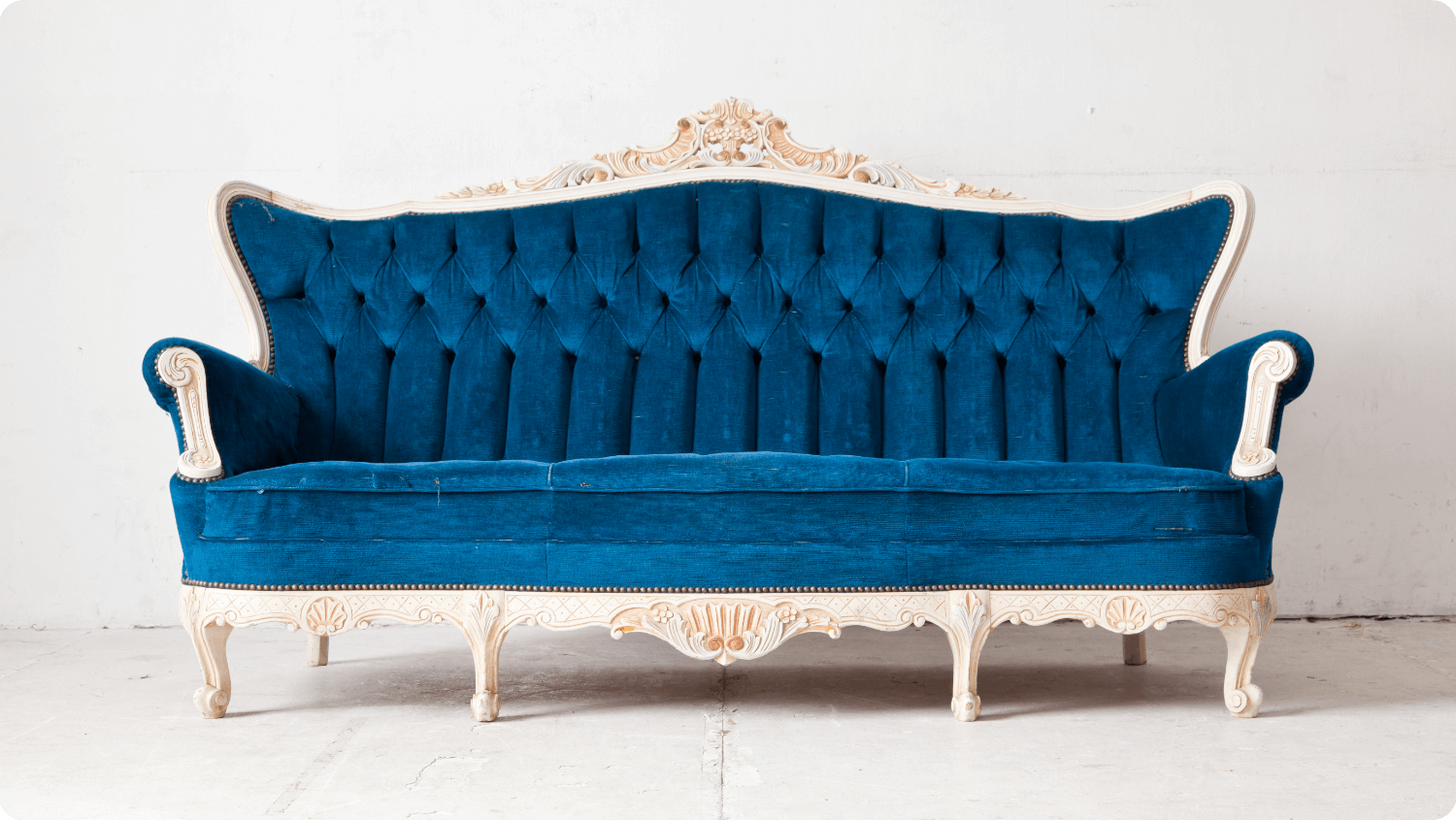 Antique carved wood sofa with blue tufted velvet in re-home old furniture