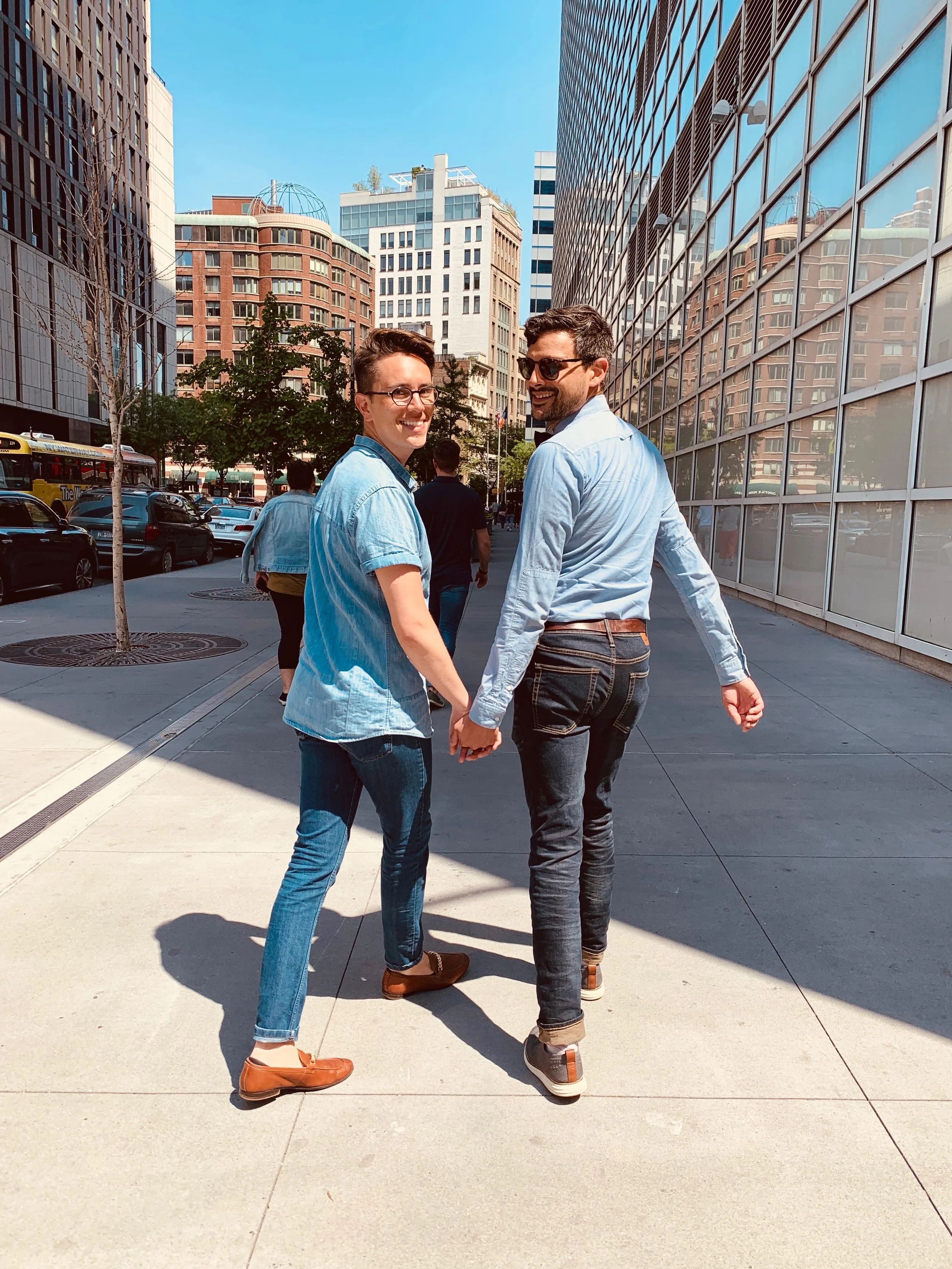 Two men holding hands and smiling