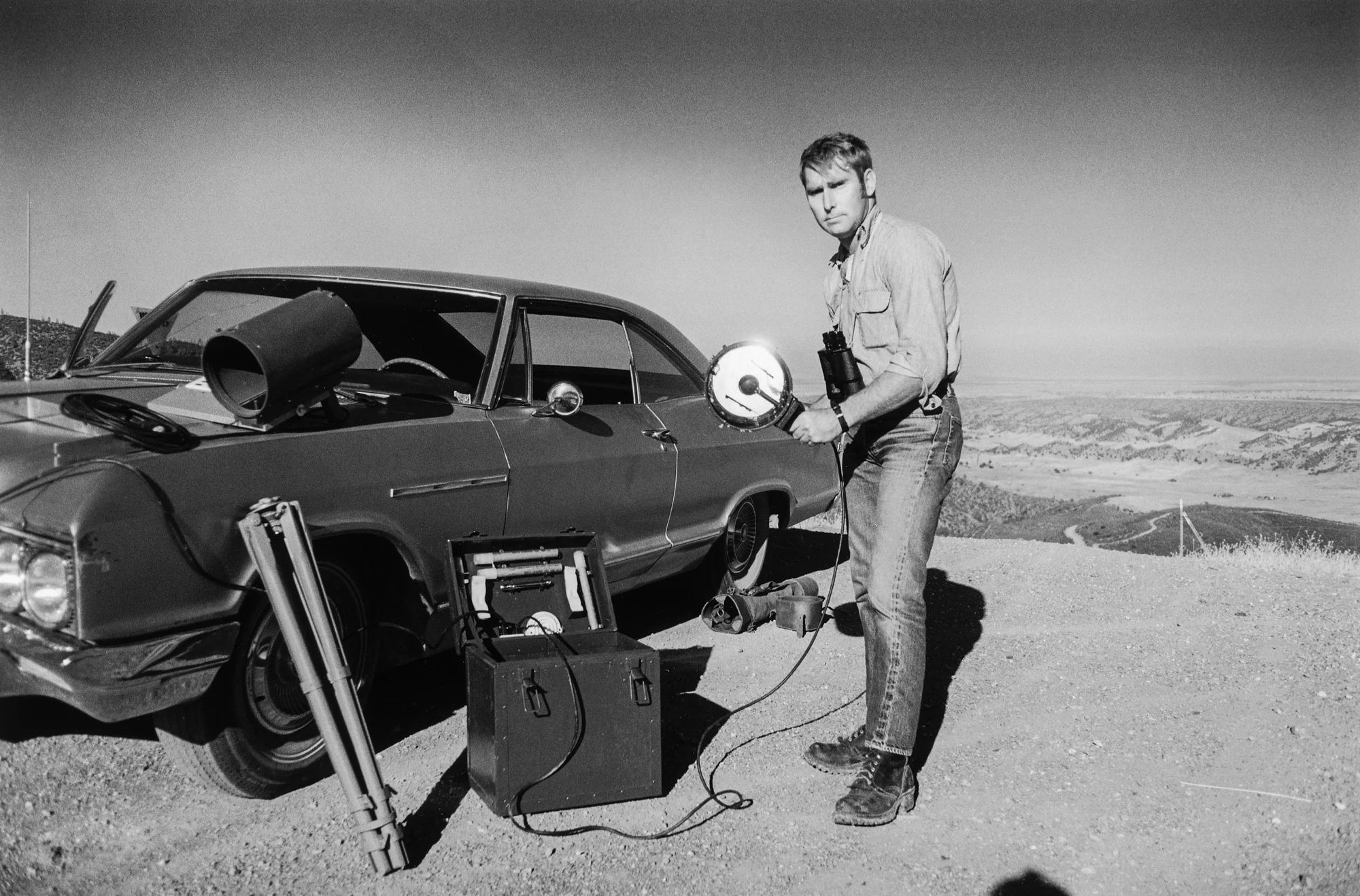 Orlando Toroni spends his nights tracking and signaling spaceships hiding behind satellites, using an aircraft signaling light. Orland, California 1977.