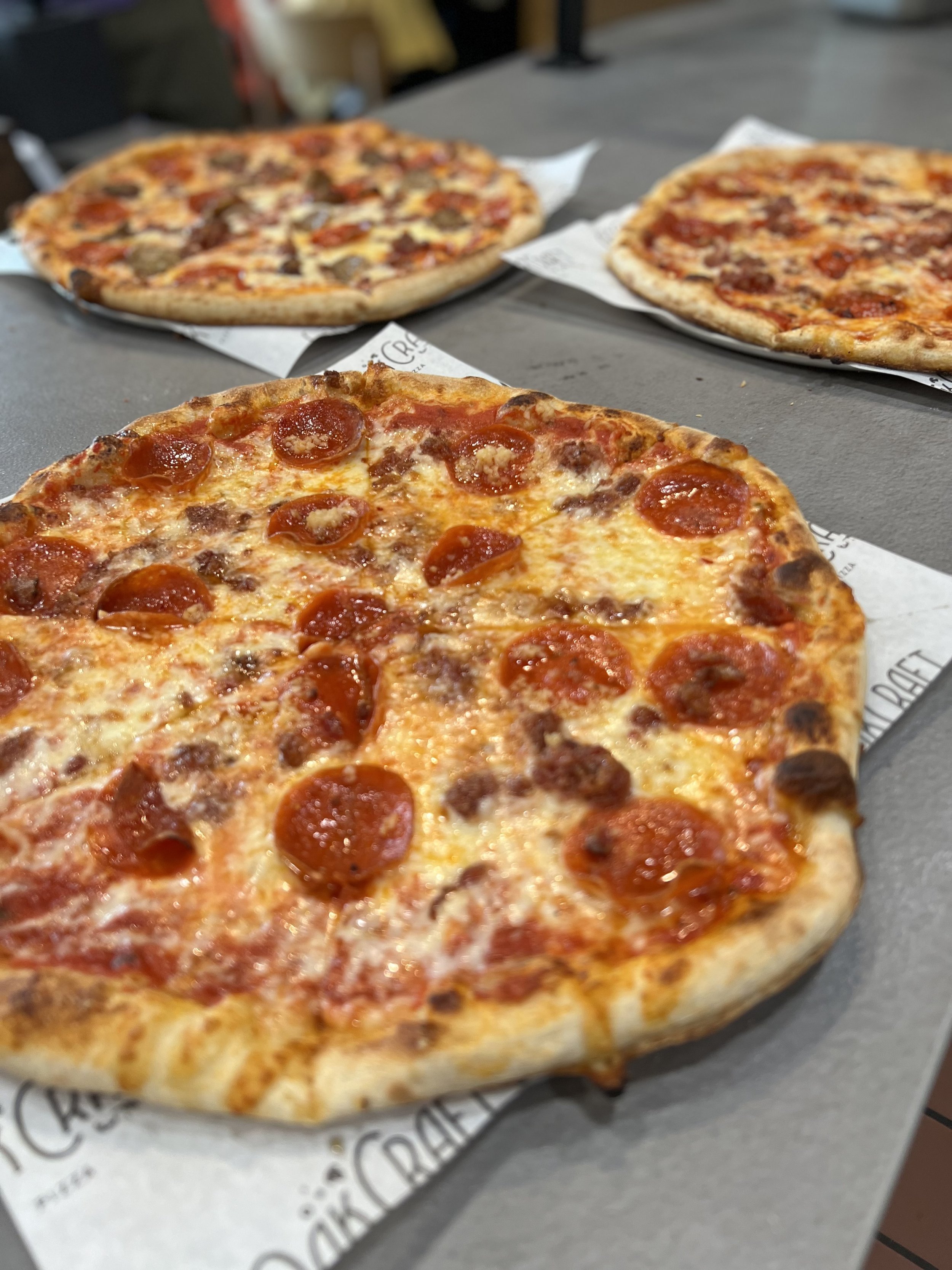 3 pizzas on hand off counter.JPG