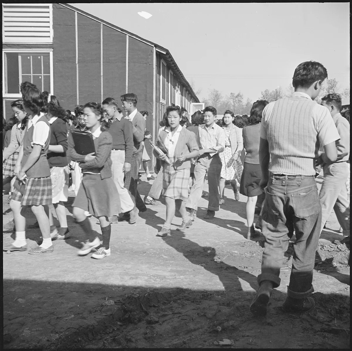 Changing classes at the temporary high school quarters – Rohwer Relocation Center, Arkansas. Courtesy of the National Archives and Records Administration.