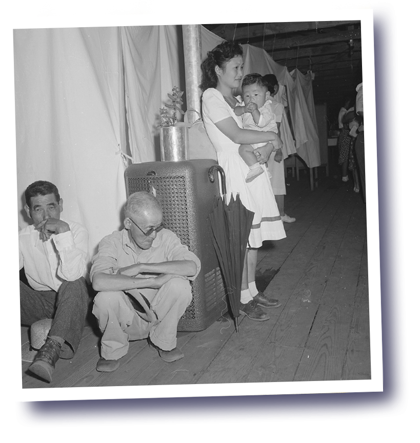 Manzanar Relocation Center, Manzanar, California. A typical interior scene in one of the barrack apartments at this center. Note the cloth partition which lends a small amount of privacy. Photo by Dorothea Lange, courtesy of the National Archives an…