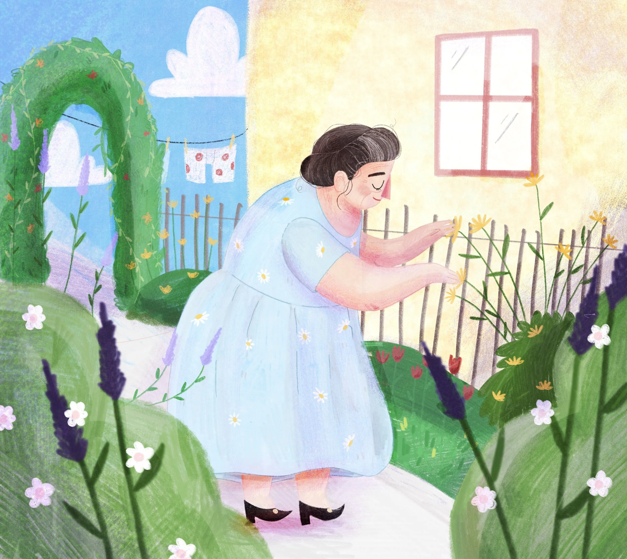 A woman in a light blue dress with daisies is tending to yellow flowers in a garden near a yellow house with a window. There are lush green bushes, lavender, and other flowers around her, with an arched green entrance and a clothesline with laundry h
