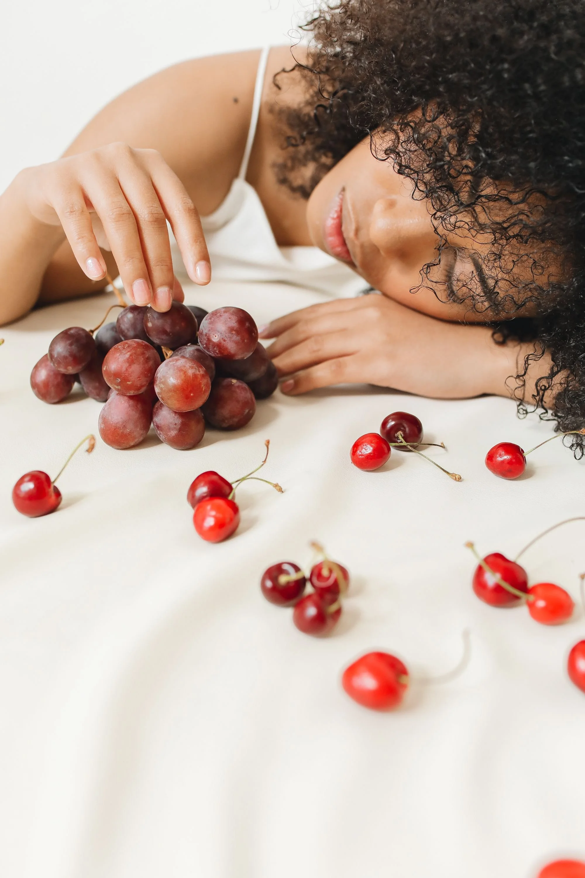 Woman resting comfortably during plastic surgery recovery while supporting healing with hydration and proper nutrition.