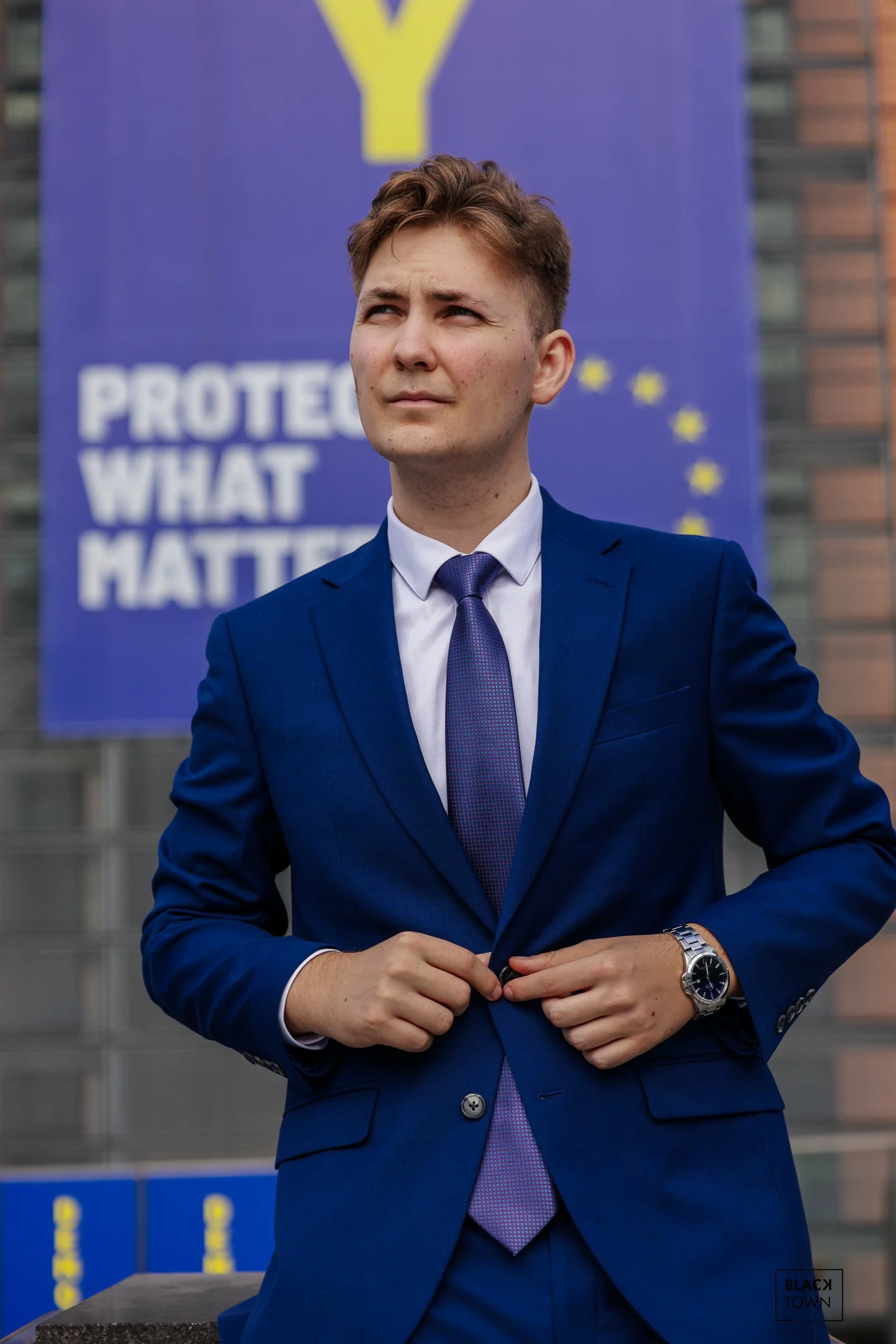Portrait de Filip en costume bleu devant les drapeaux de l'UE au Quartier Européen à Bruxelles par Blacktown Studio