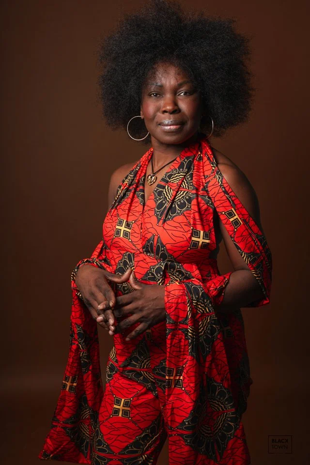 Portrait artistique en studio réalisé par Blacktown Bruxelles. Femme souriante en tenue colorée pour book photo modèle et casting.