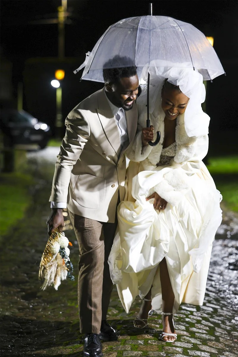 Photo de couple mariage artistique sous la pluie avec parapluie. Style cinématique et romantique réalisé par un vidéaste et photographe professionnel