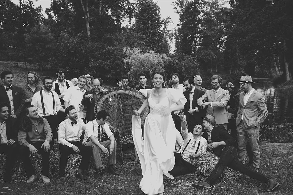 Photo de groupe mariage fun et décalée en noir et blanc. Photographe de mariage en Belgique capturant l'ambiance festive et les invités