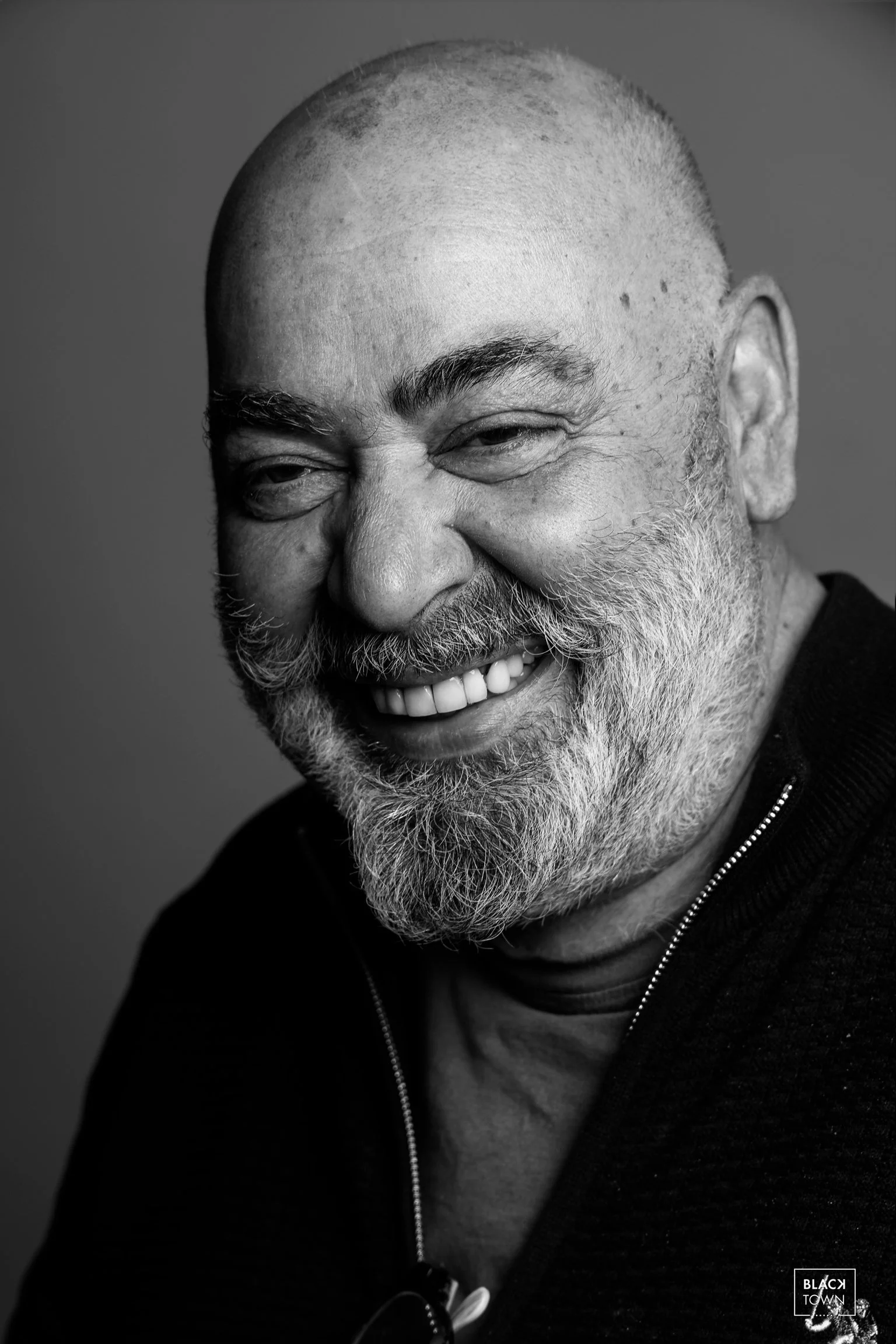 Portrait en noir et blanc d'un homme riant aux éclats. Studio photo à Saint-Gilles.